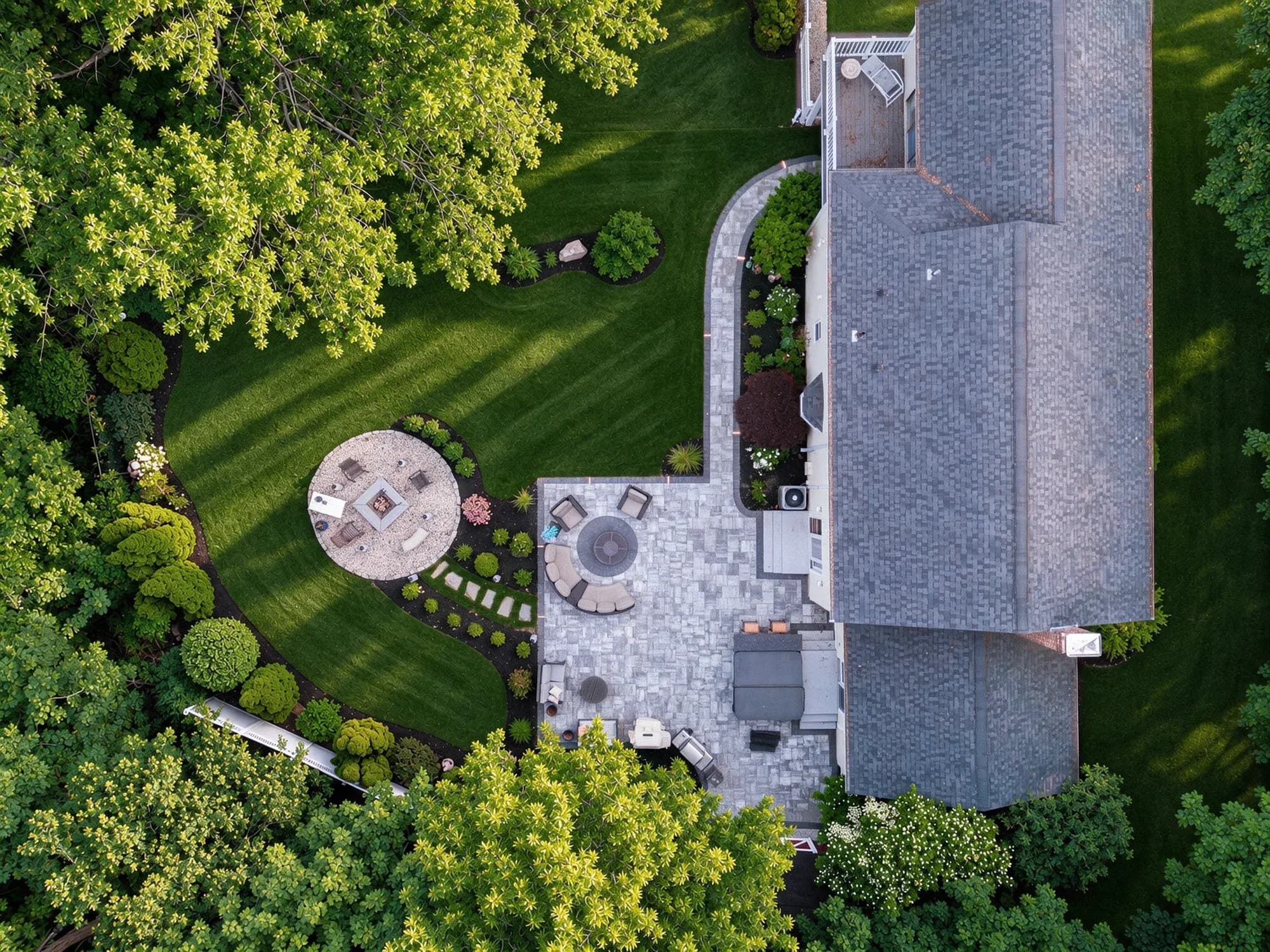 Full backyard layout with connected patio and fire-pit gathering spaces in Westwood, MA.