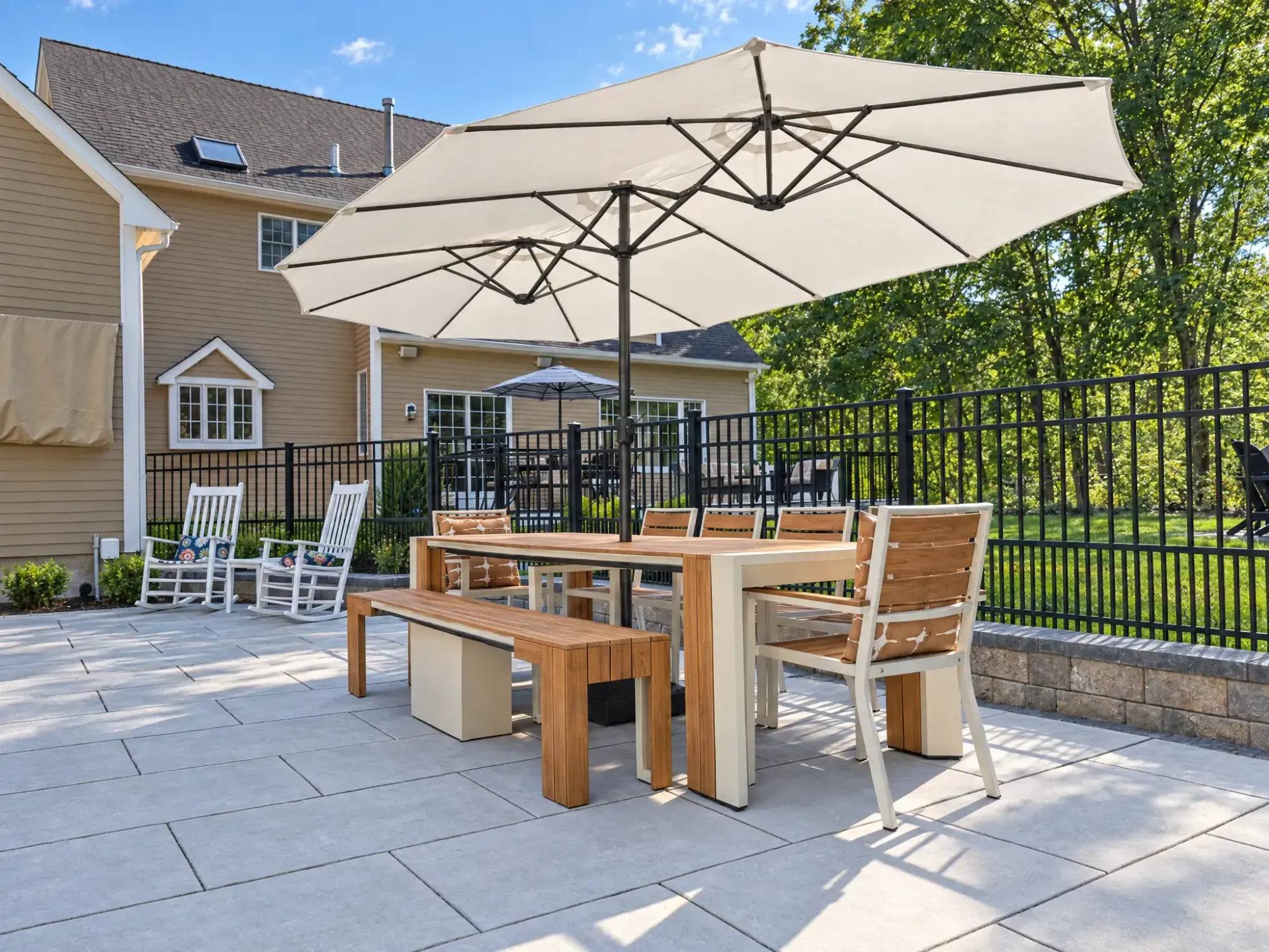 Shaded outdoor dining area on the gray paver pool patio in Easton, MA.