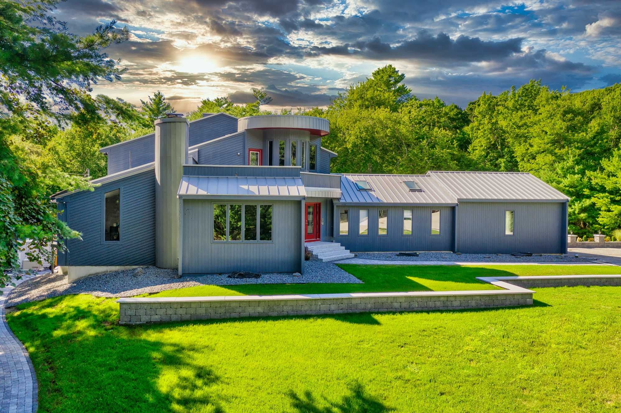 Low masonry wall framing the front lawn and entrance at sunset.