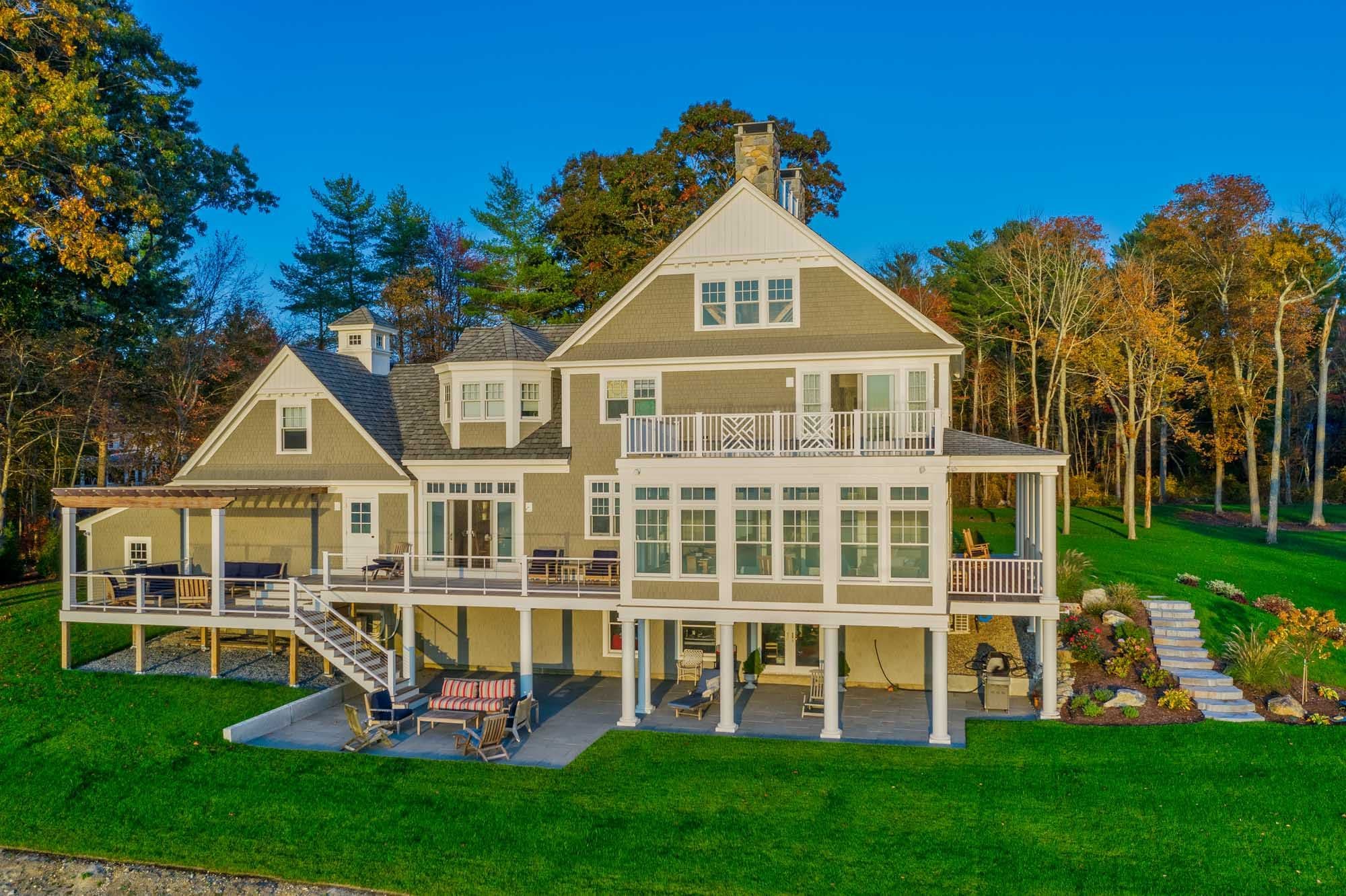 View from the lawn of the waterfront home, lower terrace, and garden steps.