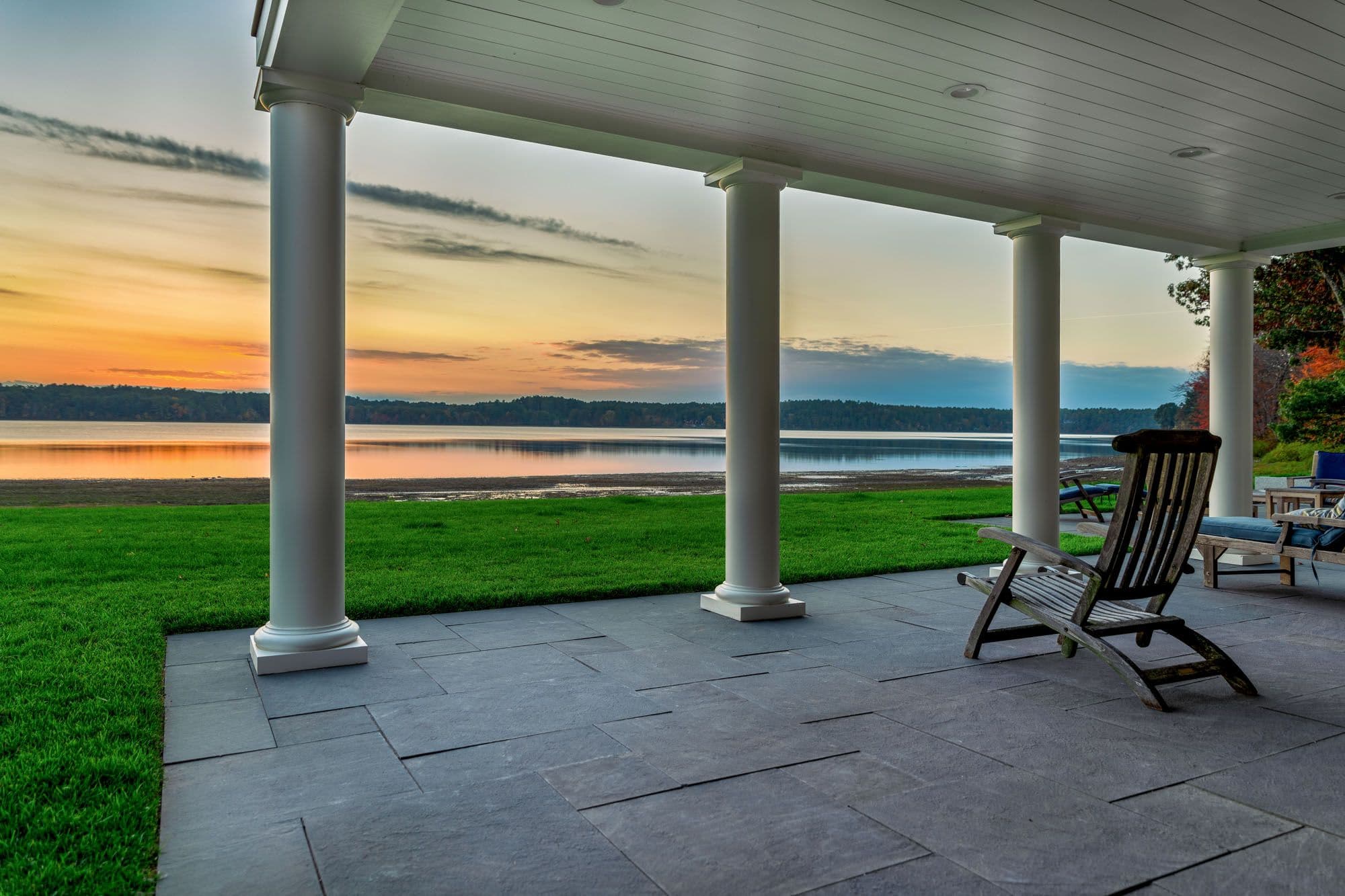 Rectangular bluestone paving and porch columns frame the waterfront view.
