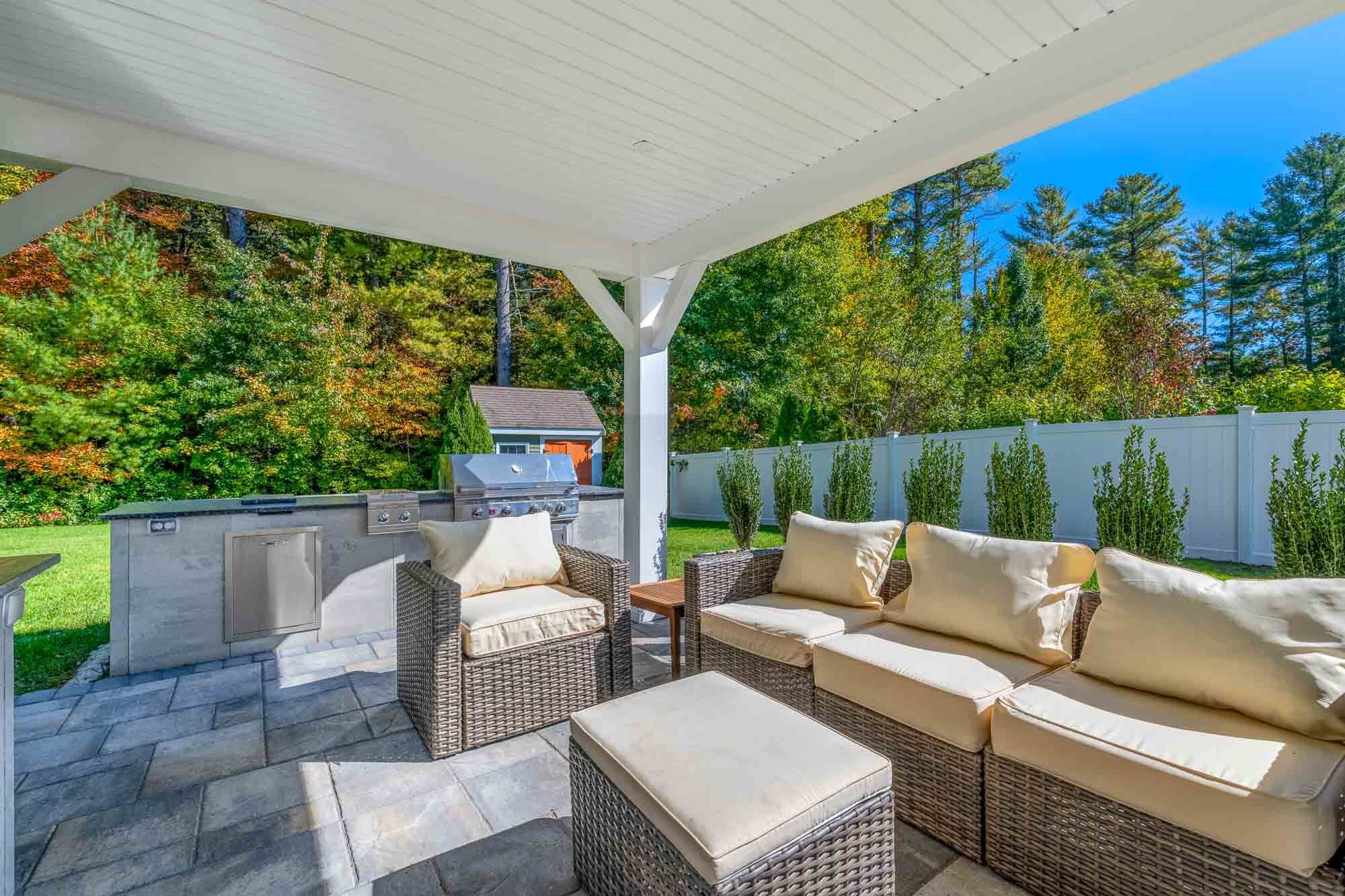 Lounge sofa and chair with the outdoor grill station behind them.