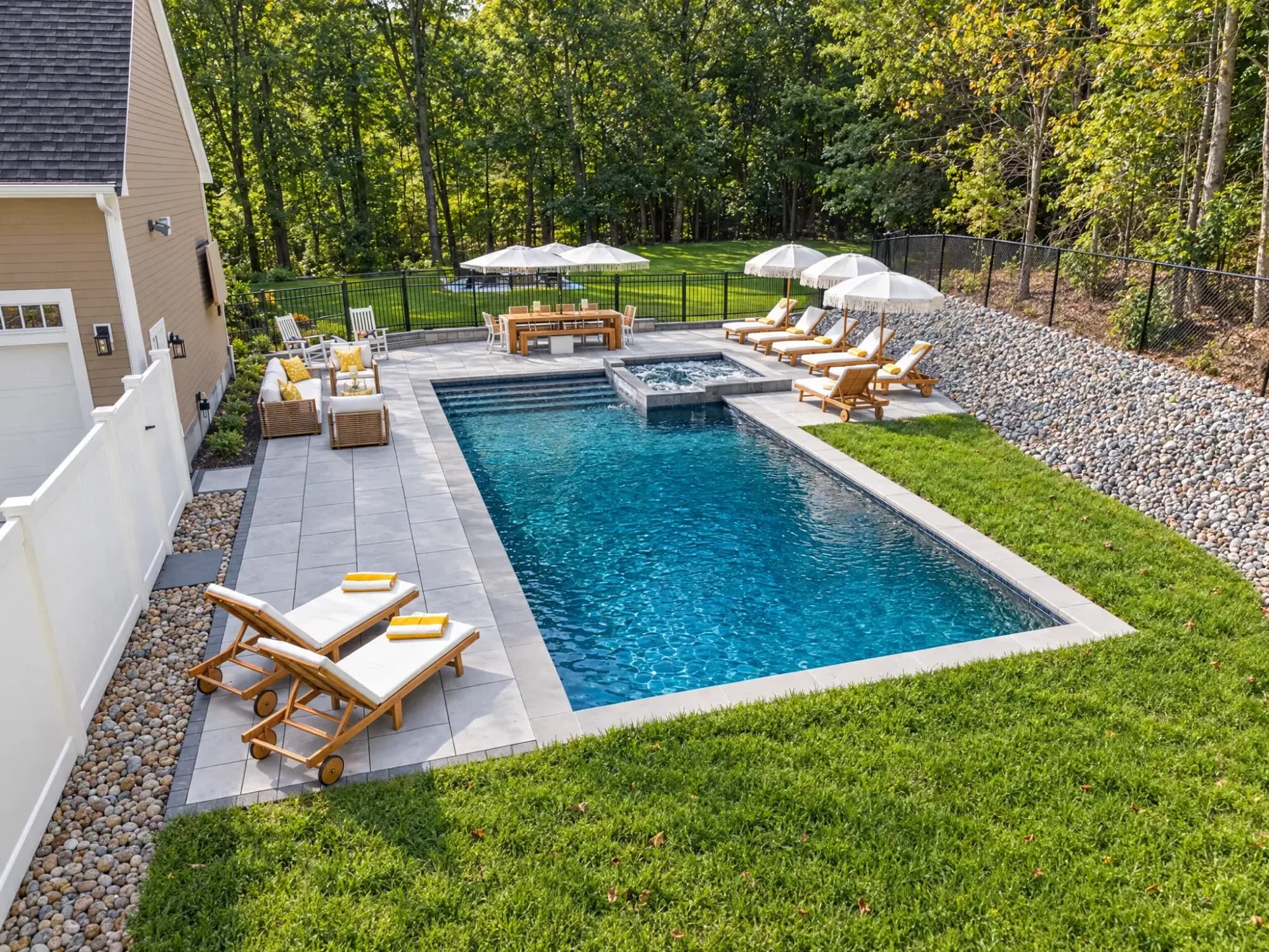Elevated view along the rectangular pool toward the spa and shaded lounge areas in Easton, MA.