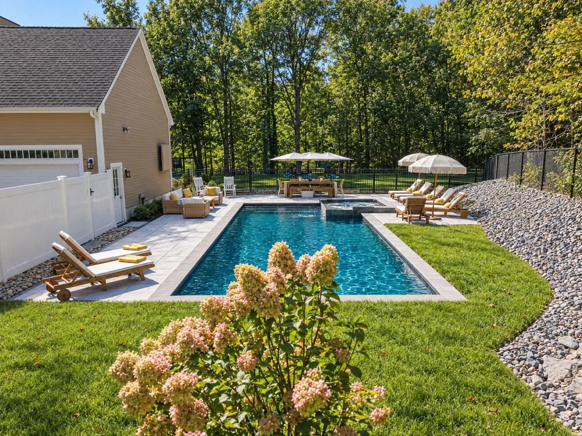 Hydrangeas frame a view across the Easton pool toward the spa and outdoor dining area.