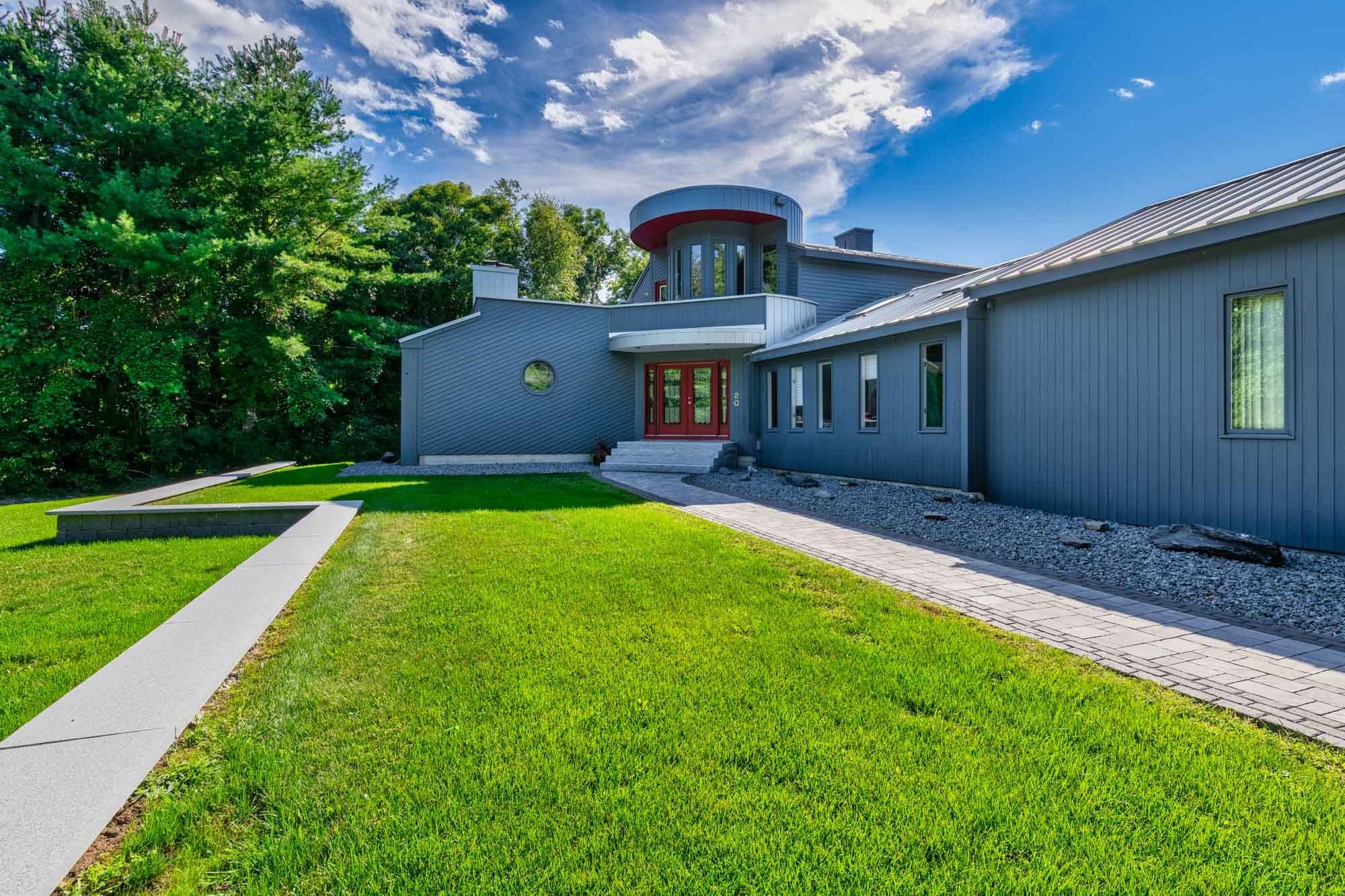 Front lawn and paver entry walkway along the gray house in North Easton.