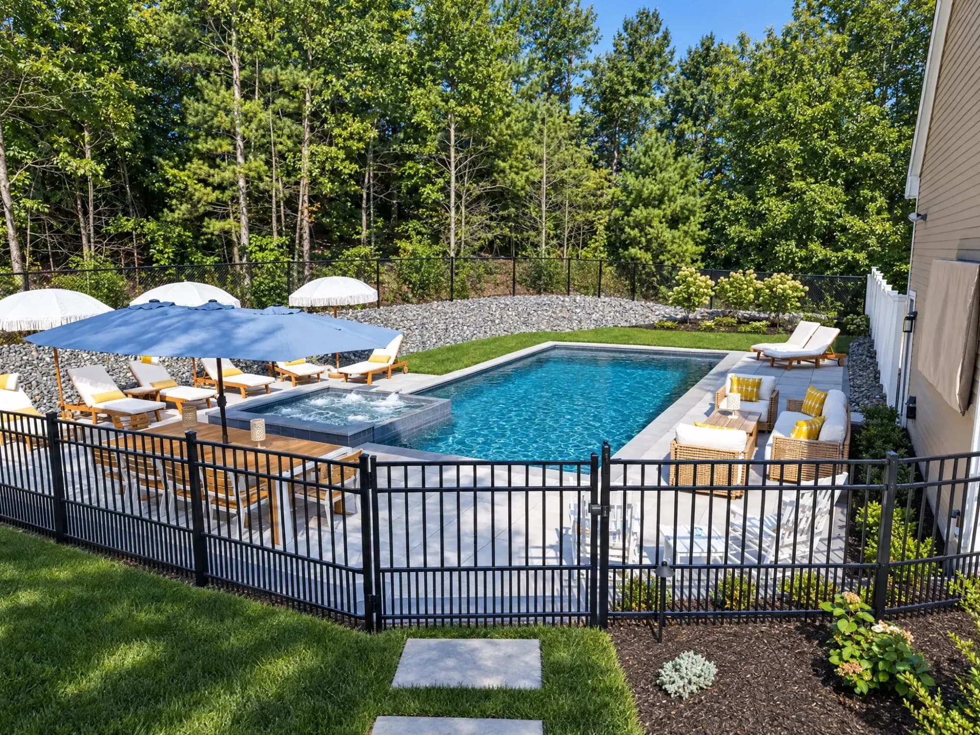Fenced pool terrace with a raised spa, shaded dining, and lounge seating in Easton, MA.
