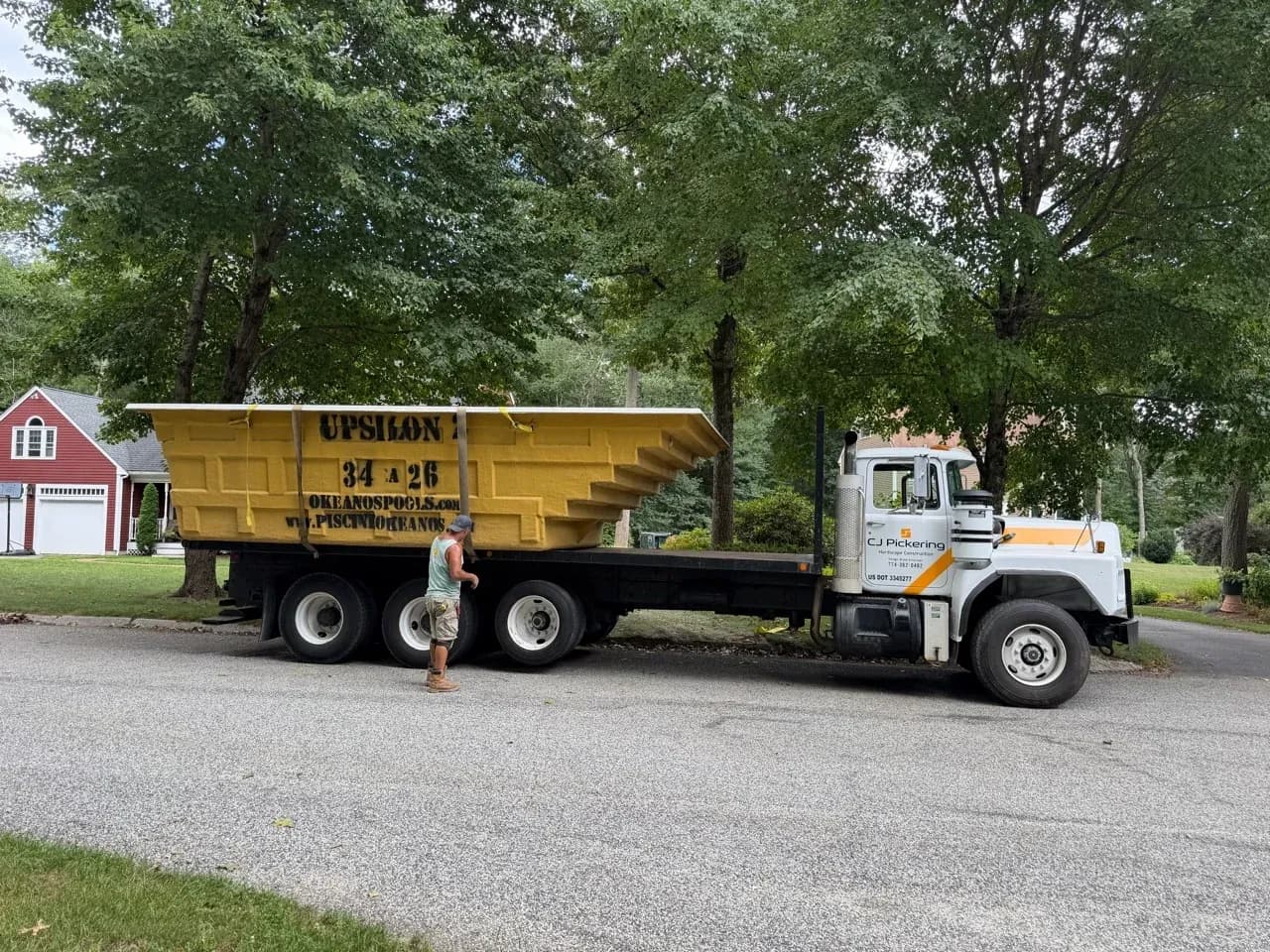 Okeanos fiberglass pool shell on a CJ Pickering flatbed delivery truck.