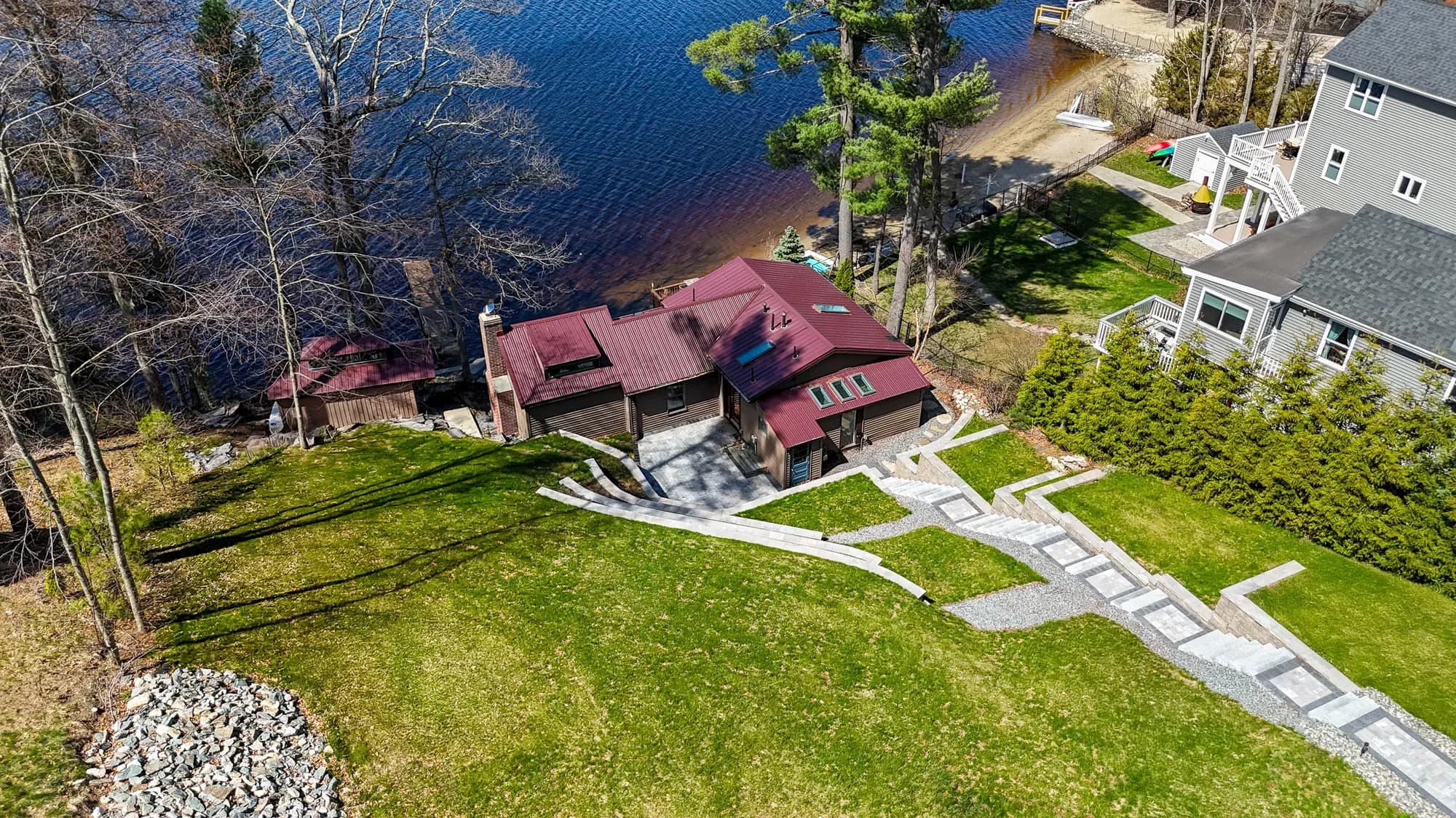 Aerial view of the waterfront home and long stairway descending through the terraced hillside.