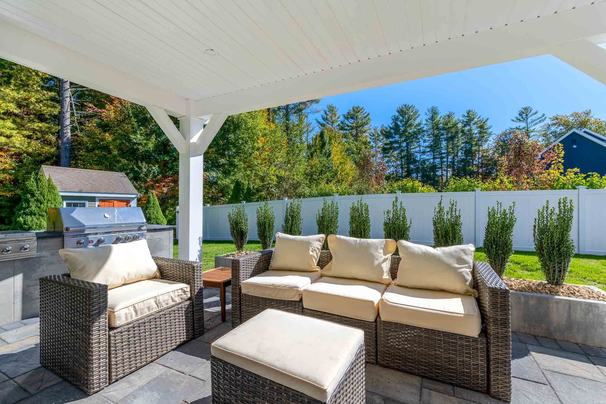 Covered lounge seating and ottoman beside the raised planting bed.