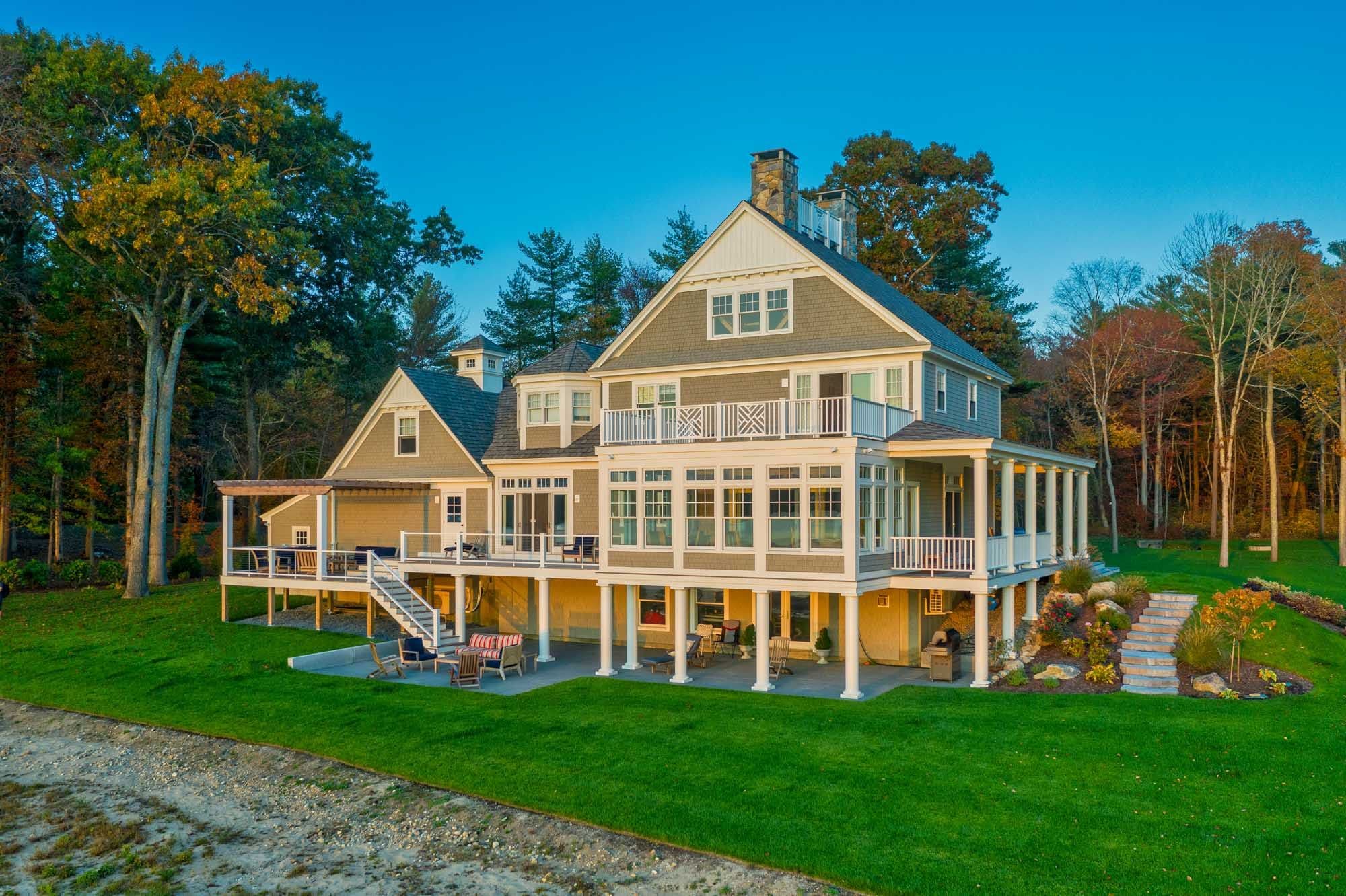 Waterfront elevation of the home with bluestone terraces and landscape steps along the lawn.