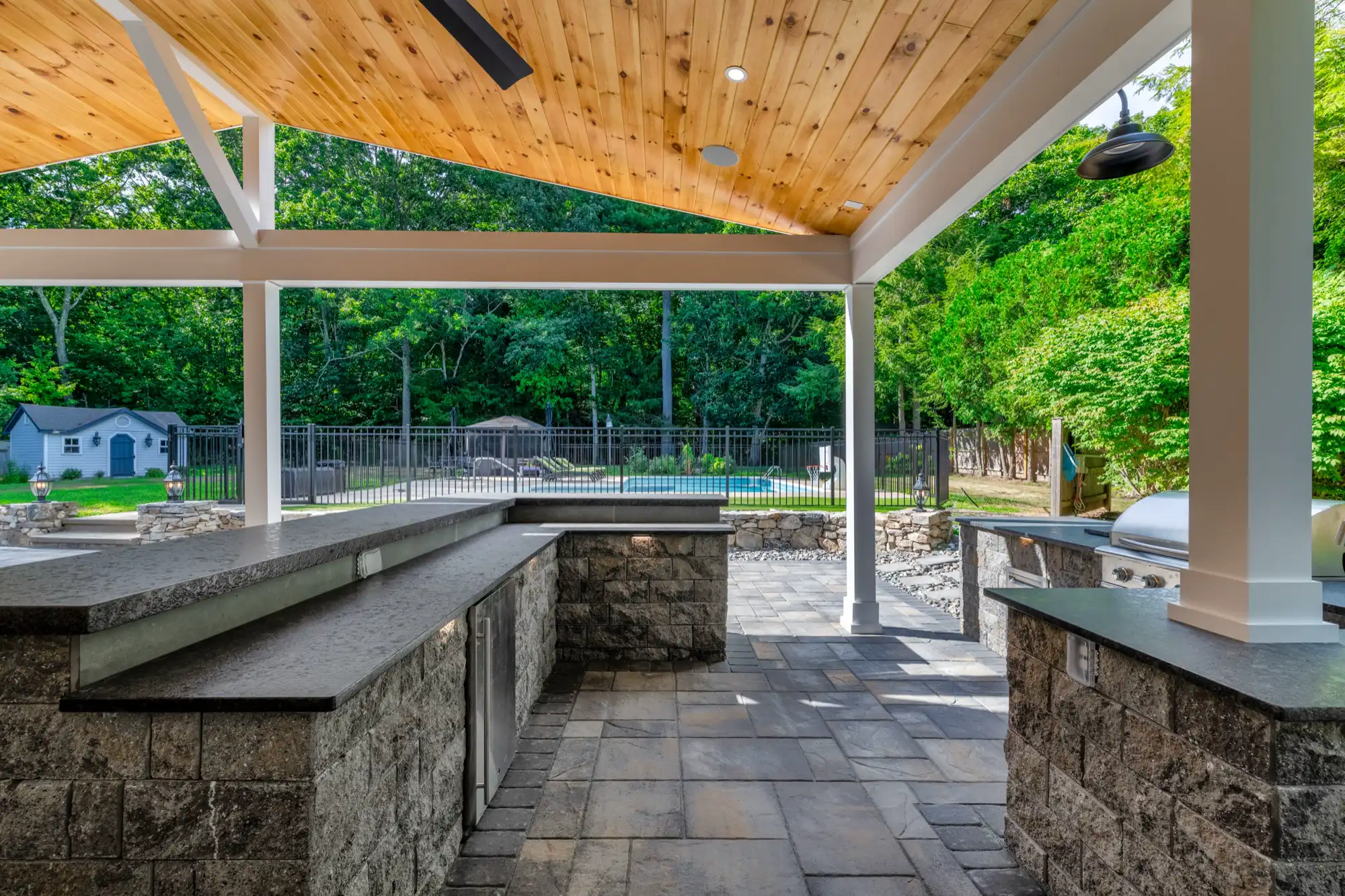 Raised bar counter overlooking the patio and fenced pool area.