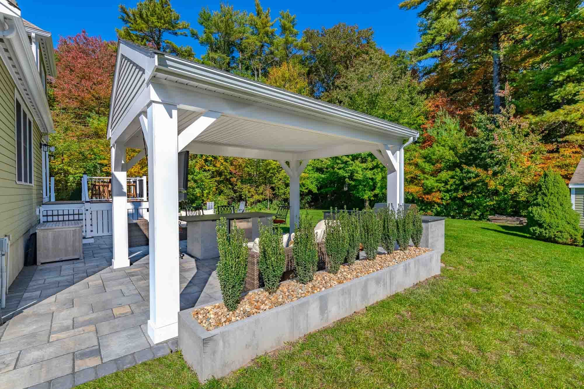 Side view of the pavilion and raised bed planted with upright shrubs.