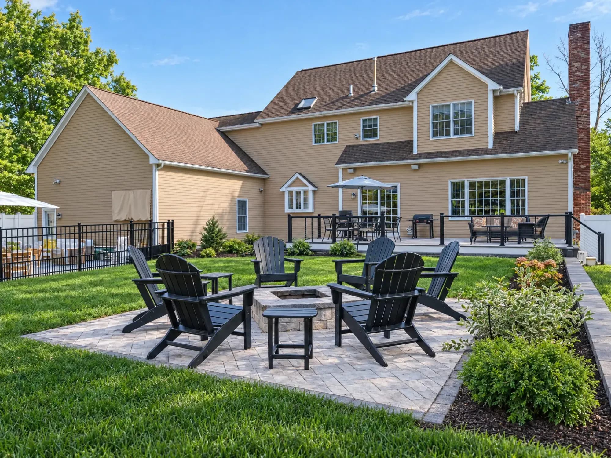 Fire-pit gathering area and planting beds overlooking the Easton house and rear deck.