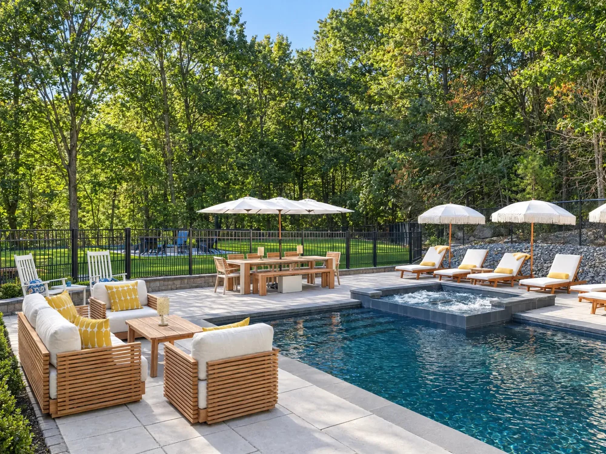 Poolside conversation seating beside the raised spa and dining terrace in Easton, MA.