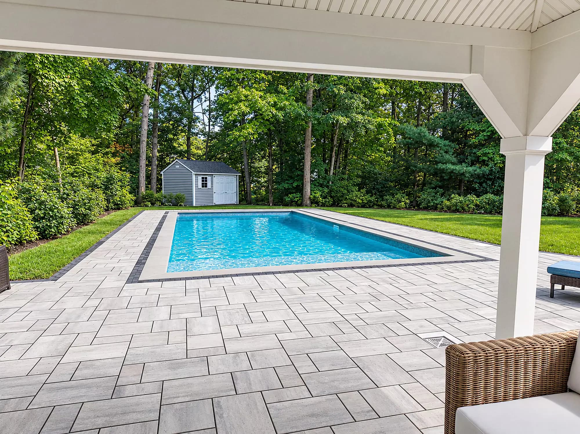 View from the pavilion across the paver patio to the pool in Mansfield, MA.